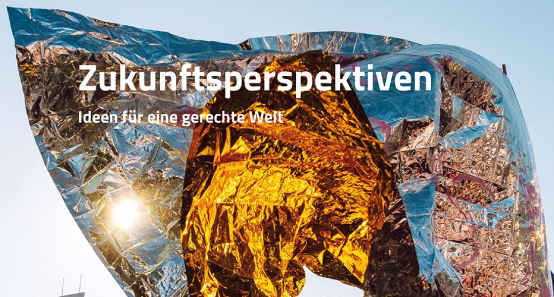 Eine goldglänzende Folie weht umher vor blauem Himmel