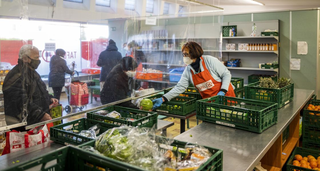 Eine Frau gibt einer anderen Frau einen Kohlkopf im Laden