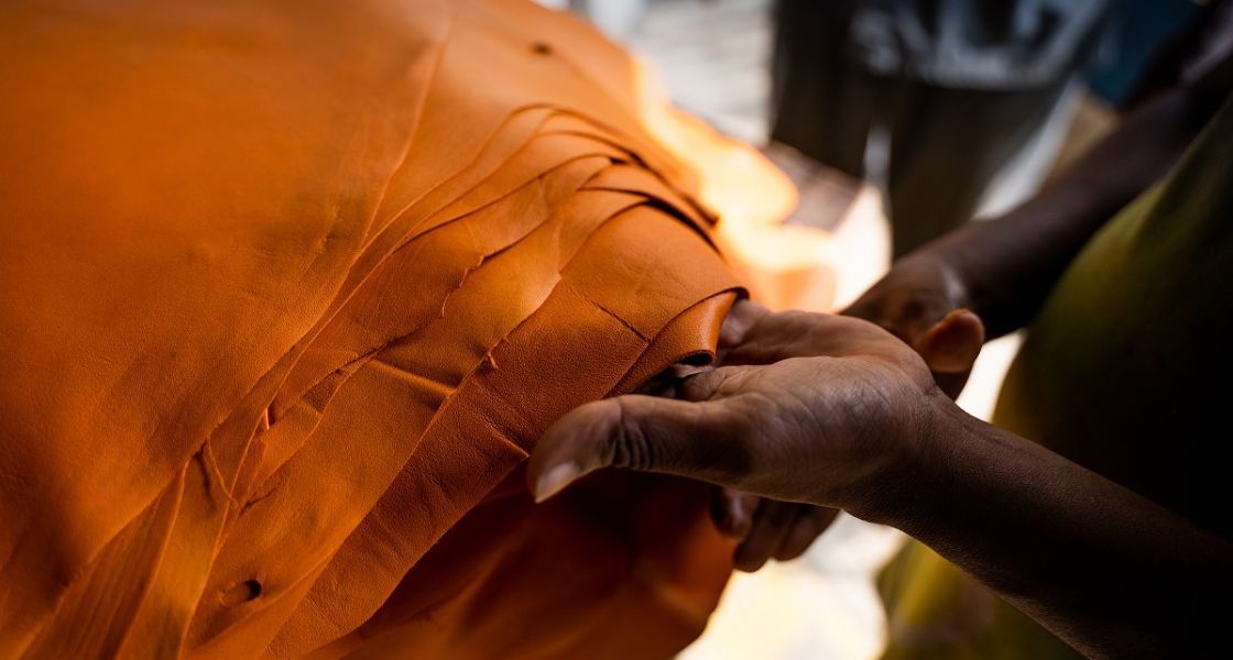 Eine Hand hält einen Stapel gelbes Leder