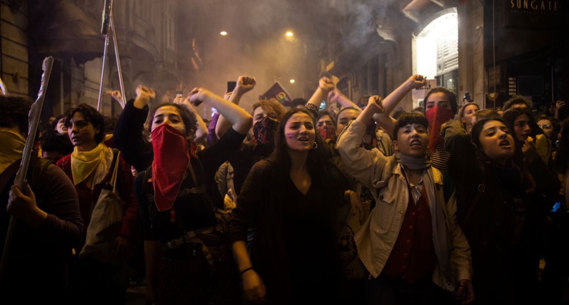 Gruppe junger Frauen mit geballten Fäusten über dem Kopf demonstrieren 