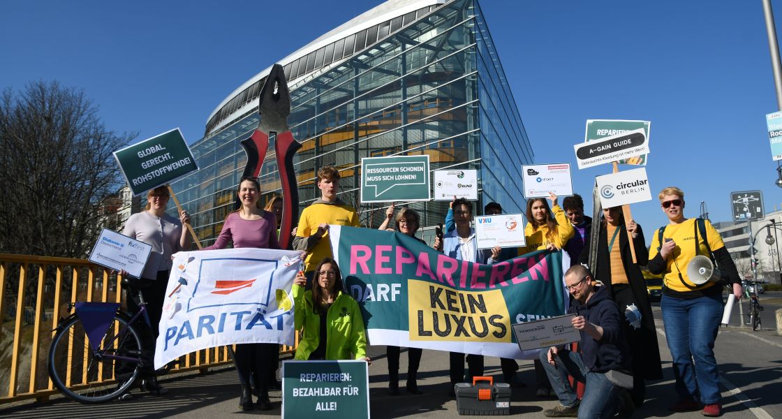 Jungen Menschen mit Schildern in der Hand demonstrieren vor dem Konrad-Adenauer-Haus für ein echtes Recht auf Reparatur