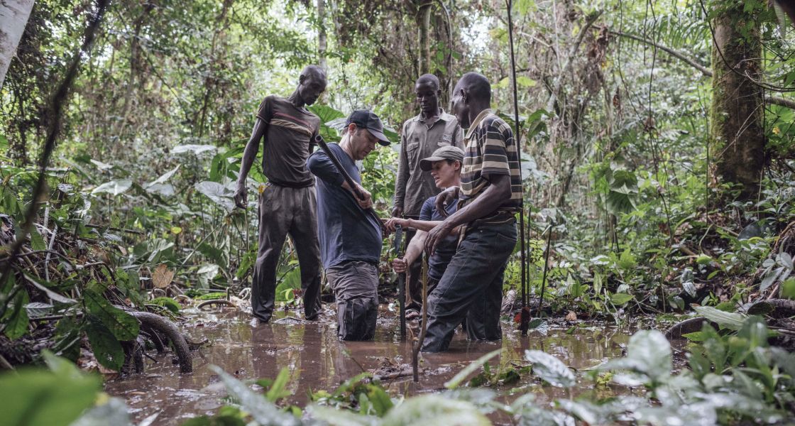 Menschengruppe entnimmt Proben aus einem Moor