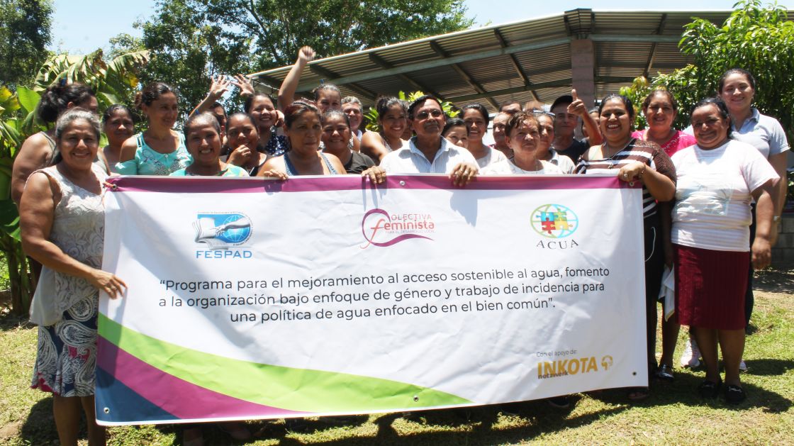 Eine Gruppe von Menschen in El Salvador halten ein großes Banner hoch