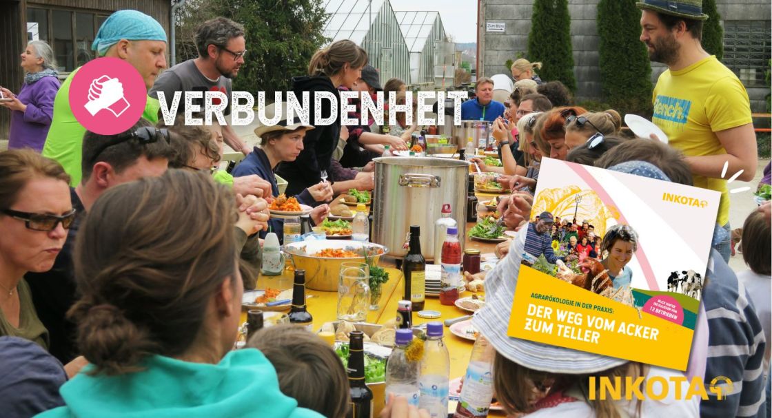 Viele Menschen sitzen an einem gedeckten Tisch und essen zusammen