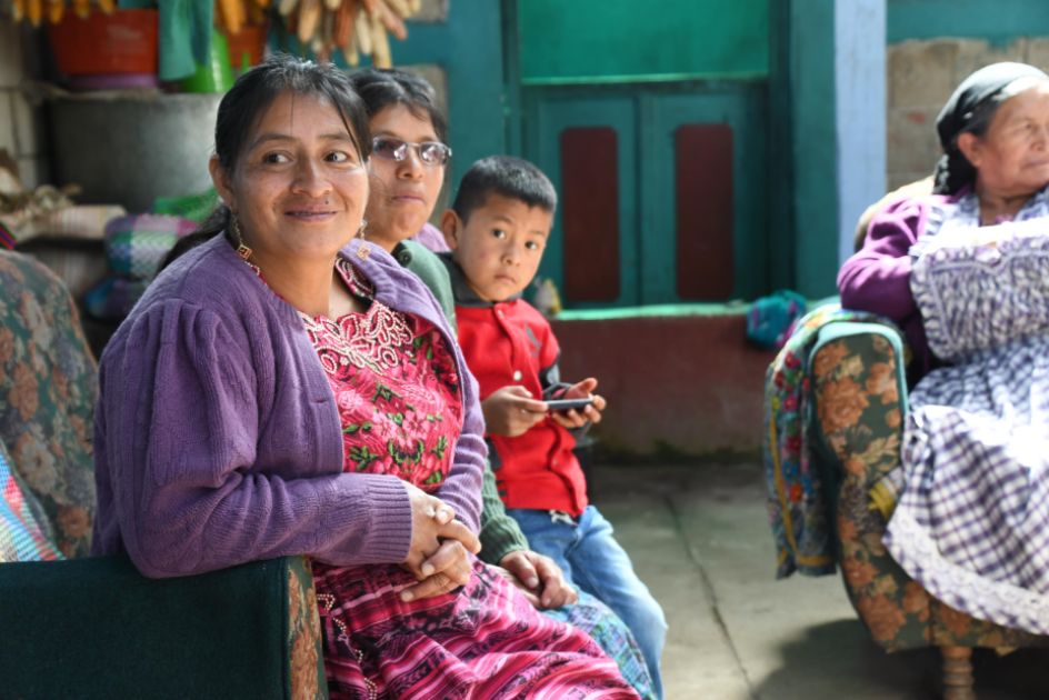 Zwei Frauen und ein Jungen sitzen zusammen auf einem Sofa