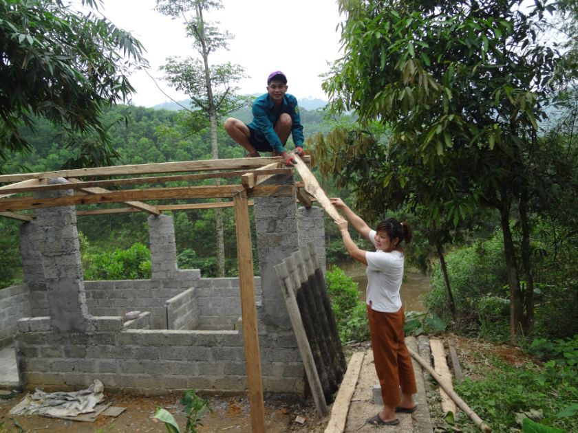 Ein Mann und eine Frau bauen einen Stall im Dschungel