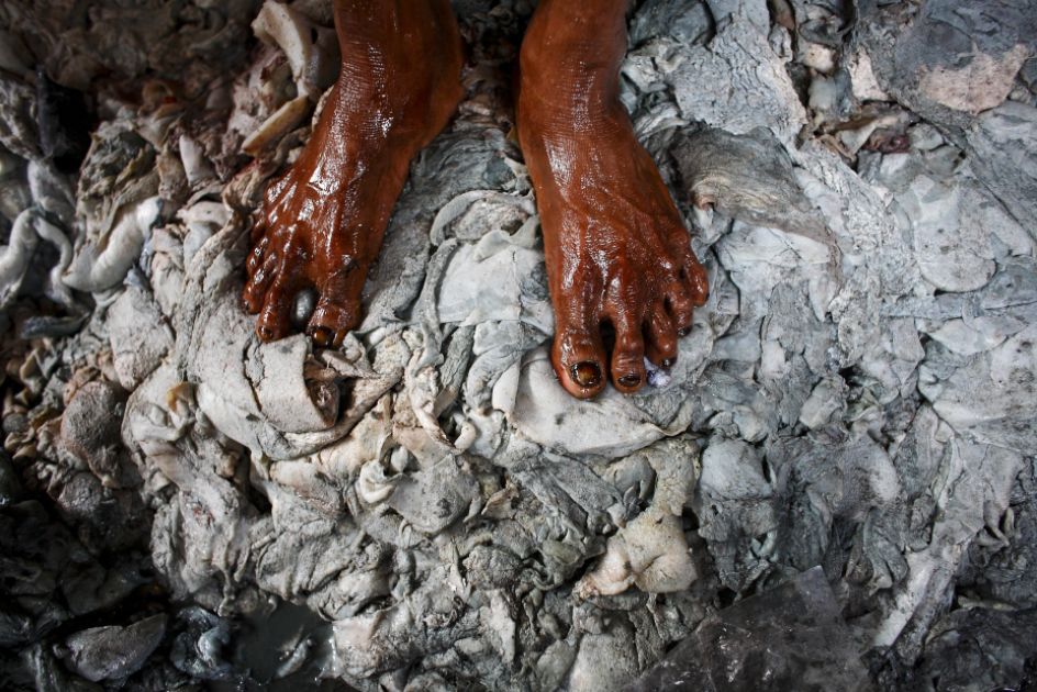 Zwei Füße stehen auf einem großen Haufen gewaschenen Lederstücke