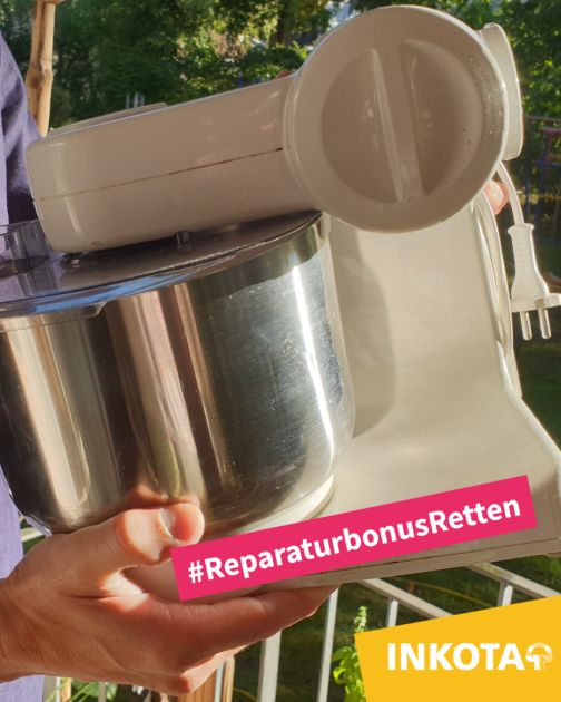 Hände halten eine weiße Küchenmaschine