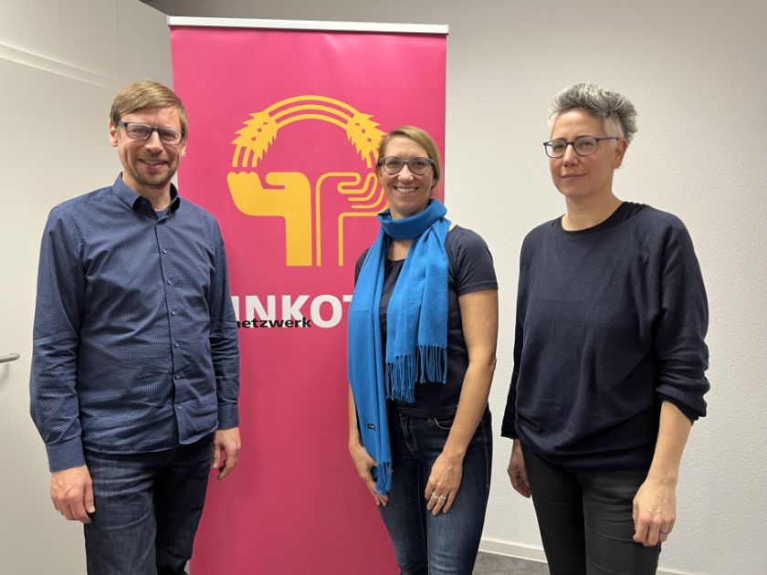 Arndt von Massenbach, Emily Büning und Magdalena Freudnenschuss vor einem Roll-up mit INKOTA-Logo