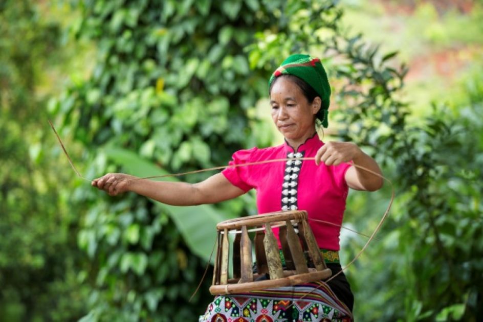 Eine Frau flechtet einen Rattankorb