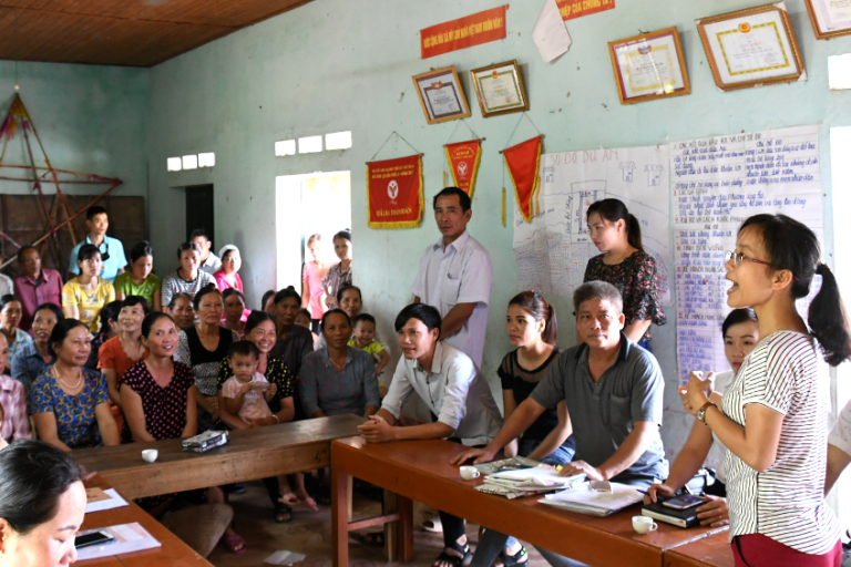 Eine Frau spricht und viele Zuhörer in einem Raum