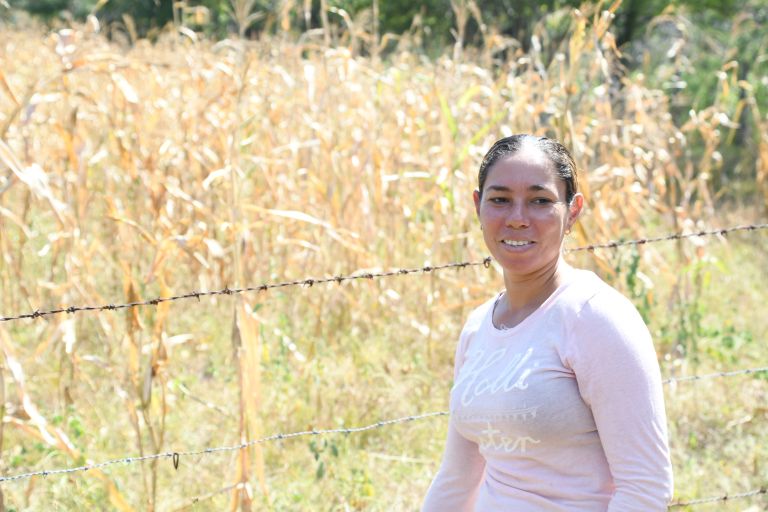 Eine Frau in einem Shirt vor einem Maisfeld