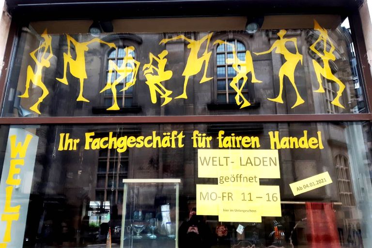 Ein großes Schaufenster mit vielen gelben Auflkleber die tanzende Figuren zeigen