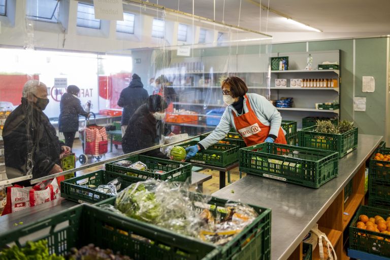 Eine Frau gibt einer anderen Frau einen Kohlkopf im Laden