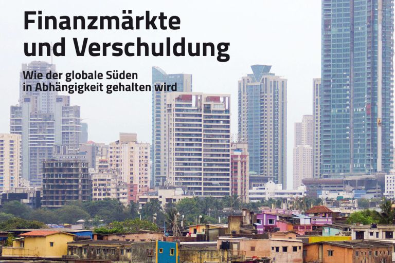 kleine bunte Häuschen ganz eng beisammen und dahinter riesenhohe Hochhäuser