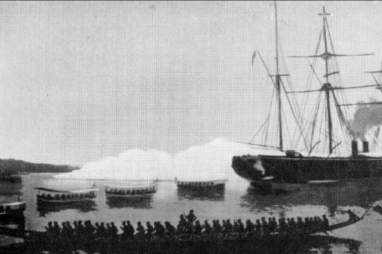 Ein Segelschiff und mehrere klene beiboote mit Menschen drauf