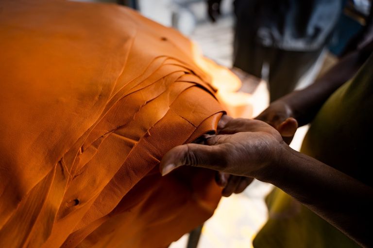 Eine Hand hält einen Stapel gelbes Leder
