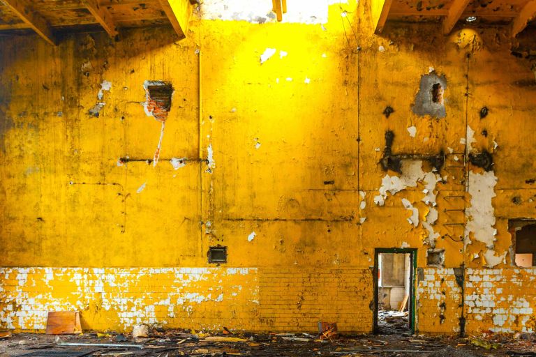 alte gelbe Fabrikwand, von der die Farbe abblättert