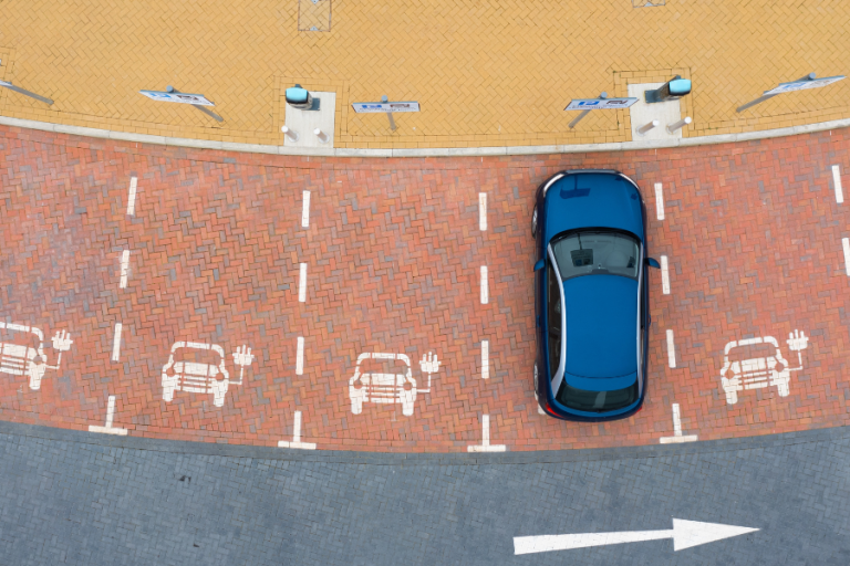 Leerer Parkplatz auf dem ein Elektroauto steht