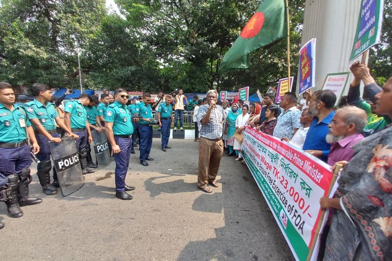 Arbeiter protestieren. Polizisten hindern sie am Weitergehen..