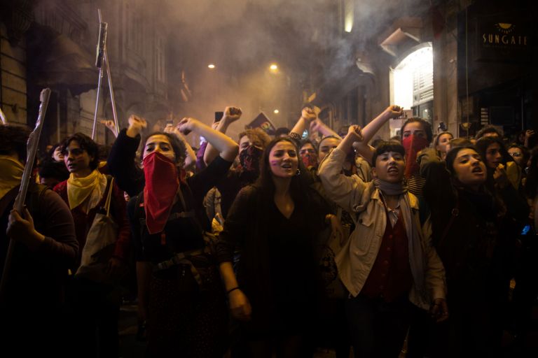 Gruppe junger Frauen mit geballten Fäusten über dem Kopf demonstrieren 