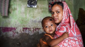Eine indische Frau mit einem Kleinkind auf dem Arm